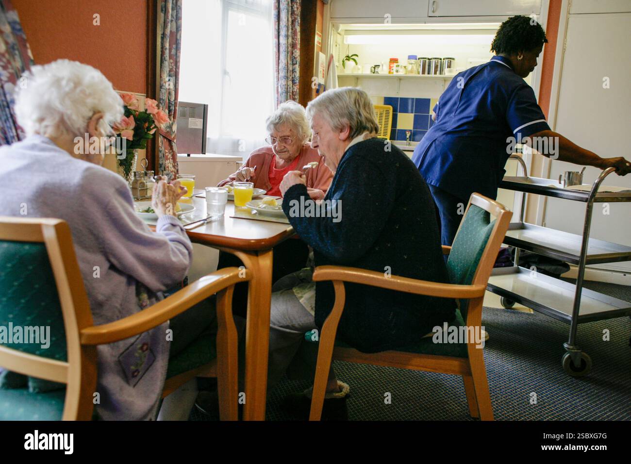 Drei Bewohner essen in einem Pflegeheim in Wolverhampton, Großbritannien. Stockfoto