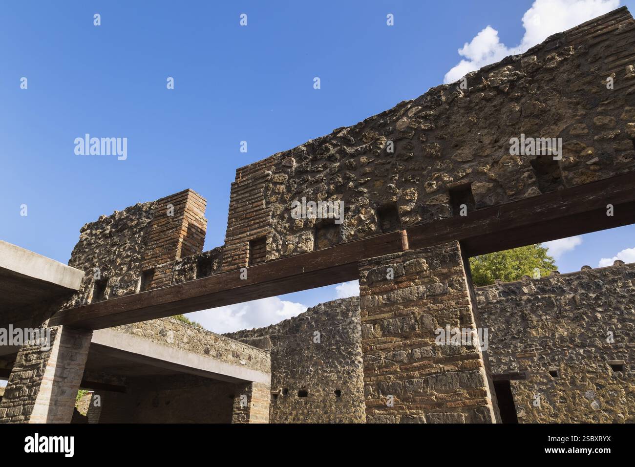 Alte Deckenmauern aus Stein und Ziegelmauern mit Öffnungen, die von Terrakotta-Ziegeln und farbigen Steinsäulen an den antiken Ruinen von Pomp unterstützt werden Stockfoto