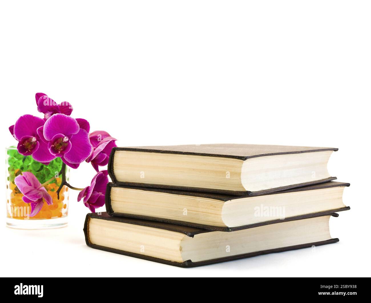 Drei braune Bücher und rosa Orchideenblume Stockfoto