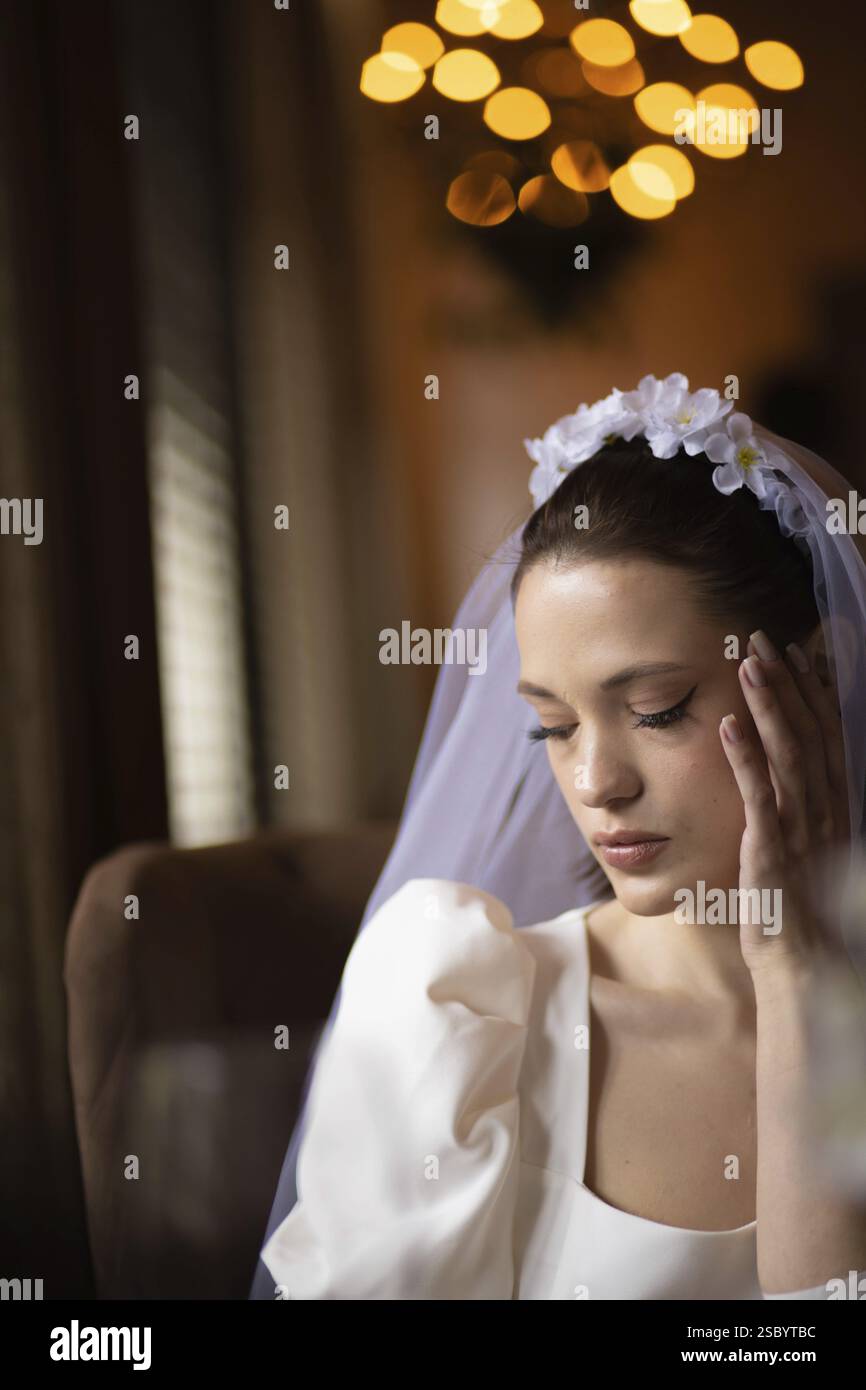 Braut mit einem traumhaften Ausdruck und einer ruhigen Aura, verstärkt durch ein Bokeh-Umgebungslicht Stockfoto