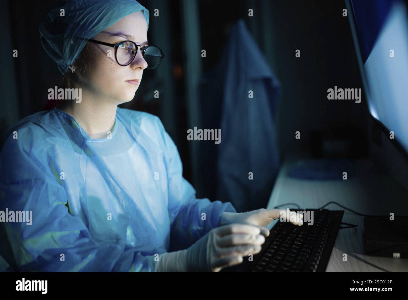 Ein Mediziner in Blauschelzschrift mit Konzentration in der Nacht Stockfoto