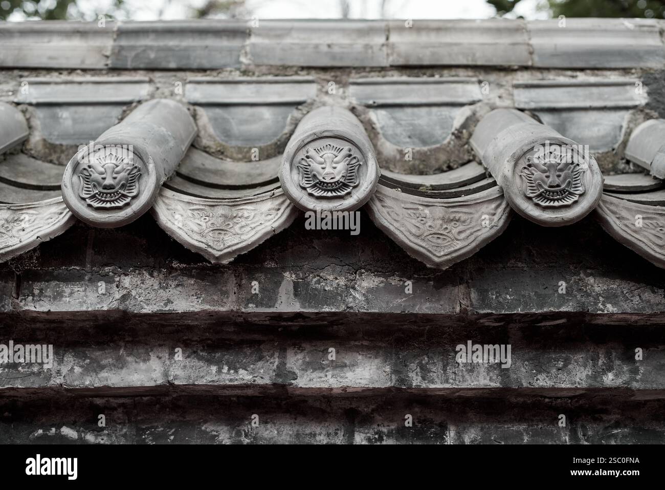 Nahaufnahme der Traufe eines alten chinesischen Gebäudes mit exquisiten Mustern auf die grauen Fliesen Stockfoto