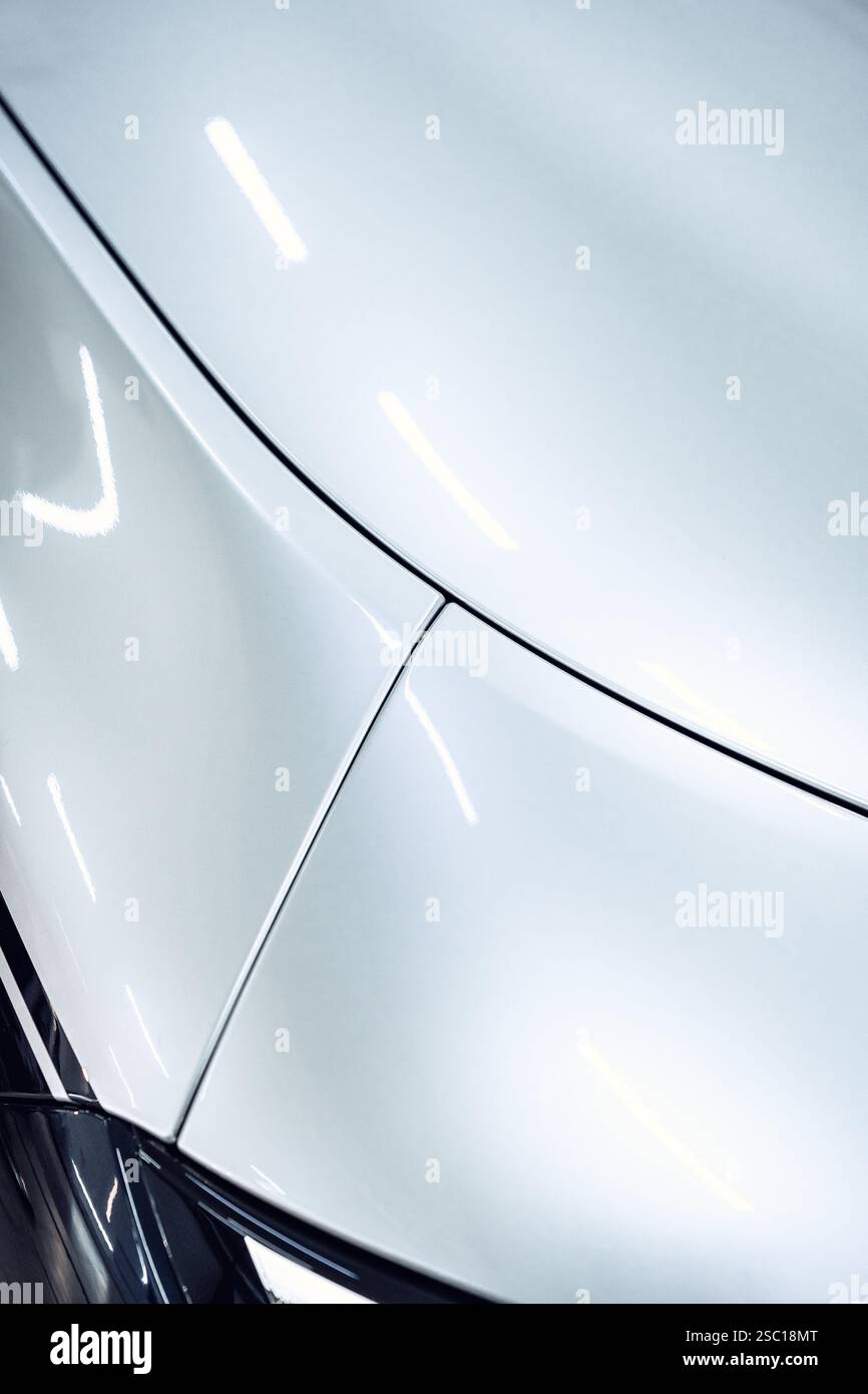 Elegante weiße Karosserie mit glatten Kurven und polierter Oberfläche in einer gut beleuchteten Garage Stockfoto