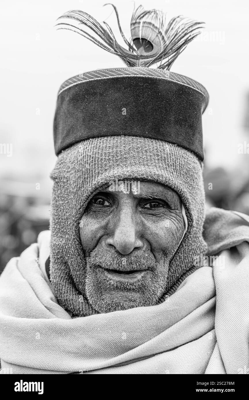 13. Januar 2025, Prayagraj, uttar Pradesh, Indien. Ein alter Mann in Kumbh Mela, der einen Hut mit einer Pfauenfeder trägt und Weisheit und Hingabe ausstrahlt. Stockfoto