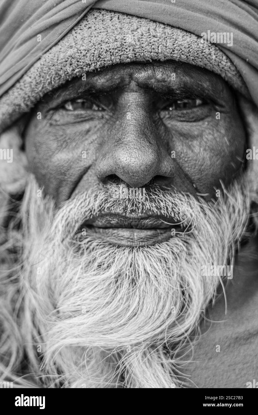 Eine schwarz-weiße Nahaufnahme eines bärtigen Sadhu, in seinem Gesicht die Geschichten von Weisheit und spiritueller Tiefe, die Frieden und Introspektion ausstrahlen. Stockfoto