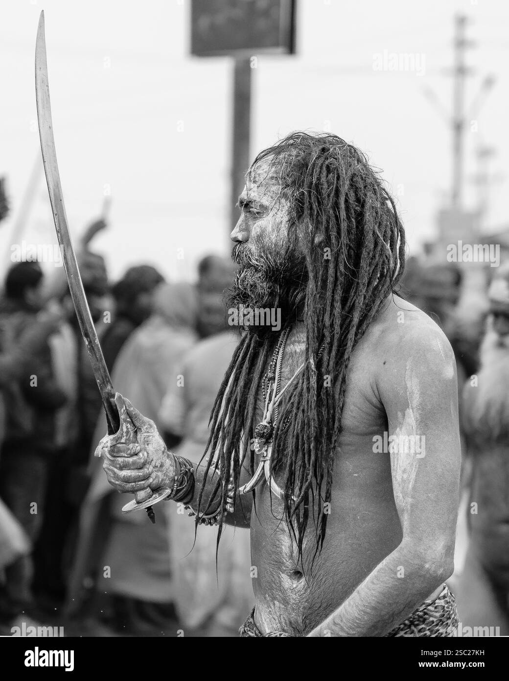 14. Januar 2025, Prayagraj, uttar Pradesh, Indien. Ein Naga Sadhu greift nach dem heiligen Bad ein Schwert und verkörpert Kraft und spirituelle Kraft. Stockfoto