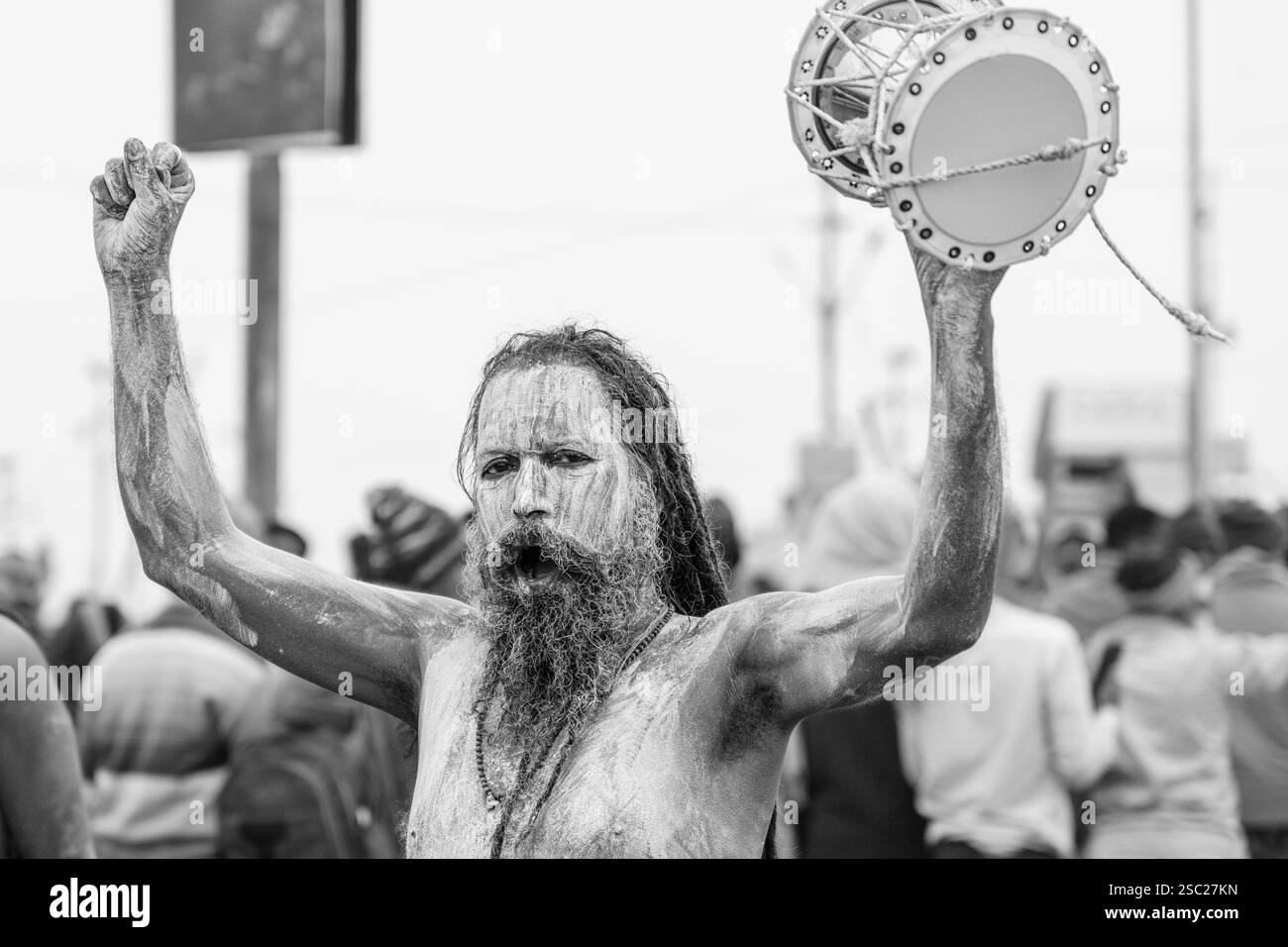 14. Januar 2025, Prayagraj, uttar Pradesh, Indien. Ein Naga Sadhu, frisch gebadet im heiligen Sangam-Wasser, hält einen Damroo in der Hand, seine Anwesenheit radi Stockfoto