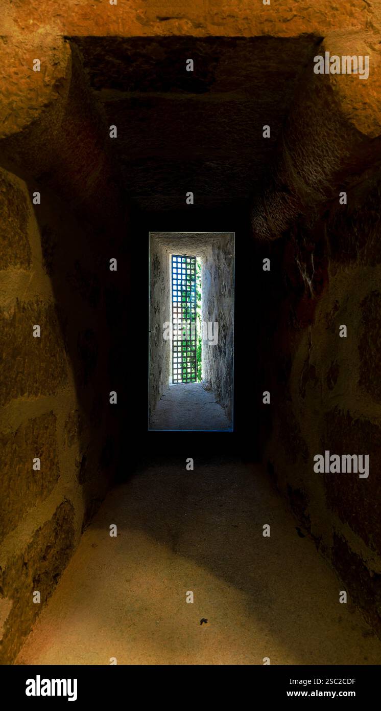 Ein schmaler, schwach beleuchteter Tunnel mit einem kleinen Fenster in der Mitte. Das Fenster ist kaum zu sehen, und der Tunnel ist schmal, sodass es sich eng anfühlt und claus Stockfoto Ein schmaler, schwach beleuchteter Tunnel mit einem kleinen Fenster in der Mitte. Das Fenster ist kaum zu sehen, und der Tunnel ist schmal, sodass es sich eng anfühlt und claus Stockfoto