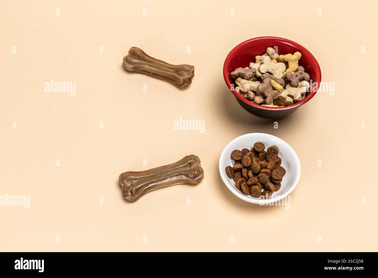 Futter für Hunde. Trockenfutter für Haustiere in Schüsseln. Granuliertes Tierfutter. Künstliches Hundekauen mit Vitaminen auf dem Boden. Gute Ernährung für Hunde. Stockfoto