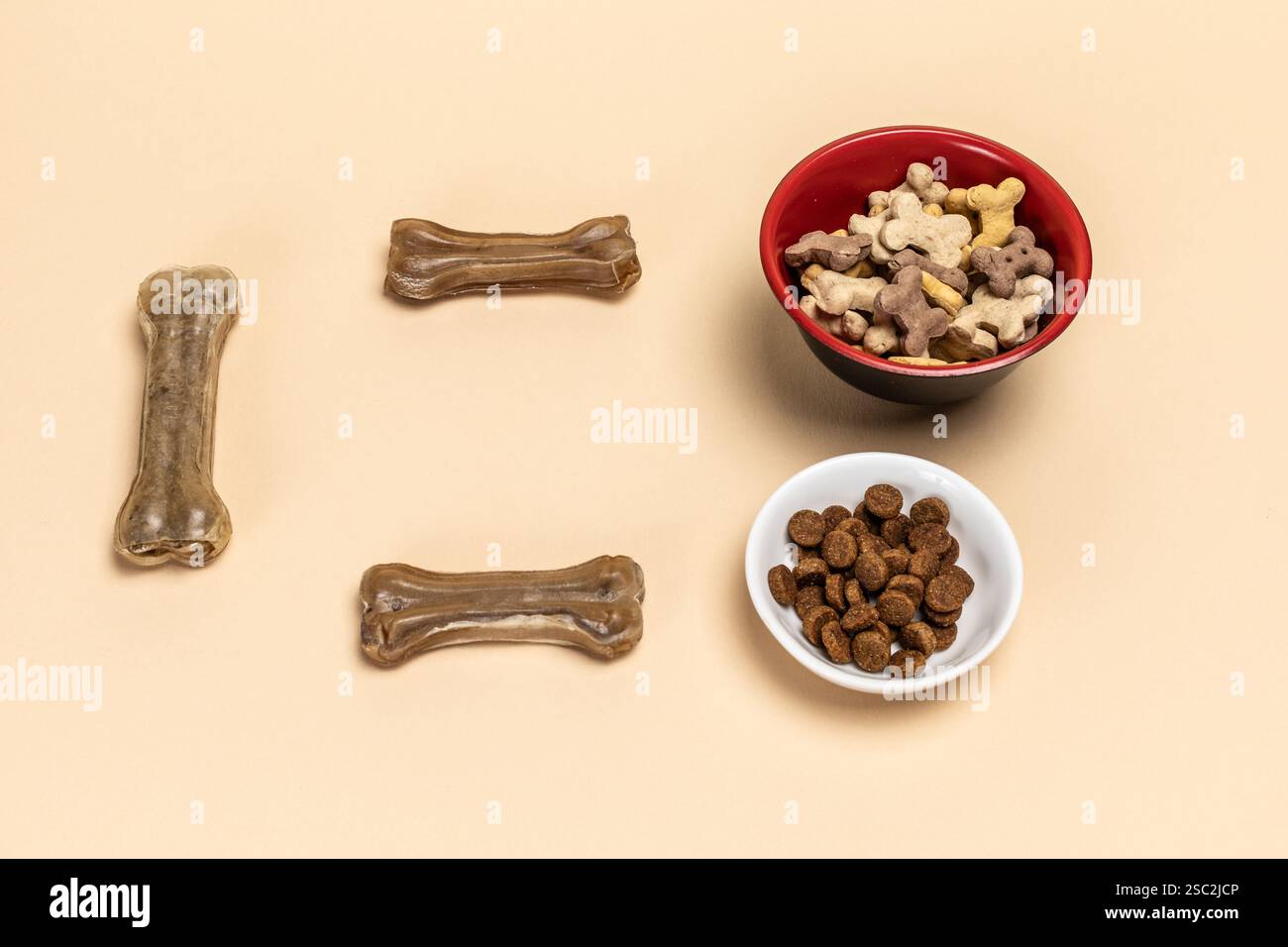 Futter für Hunde. Trockenfutter für Haustiere in Schüsseln. Granuliertes Tierfutter. Künstliches Hundekauen mit Vitaminen auf dem Boden. Gute Ernährung für Hunde. Stockfoto