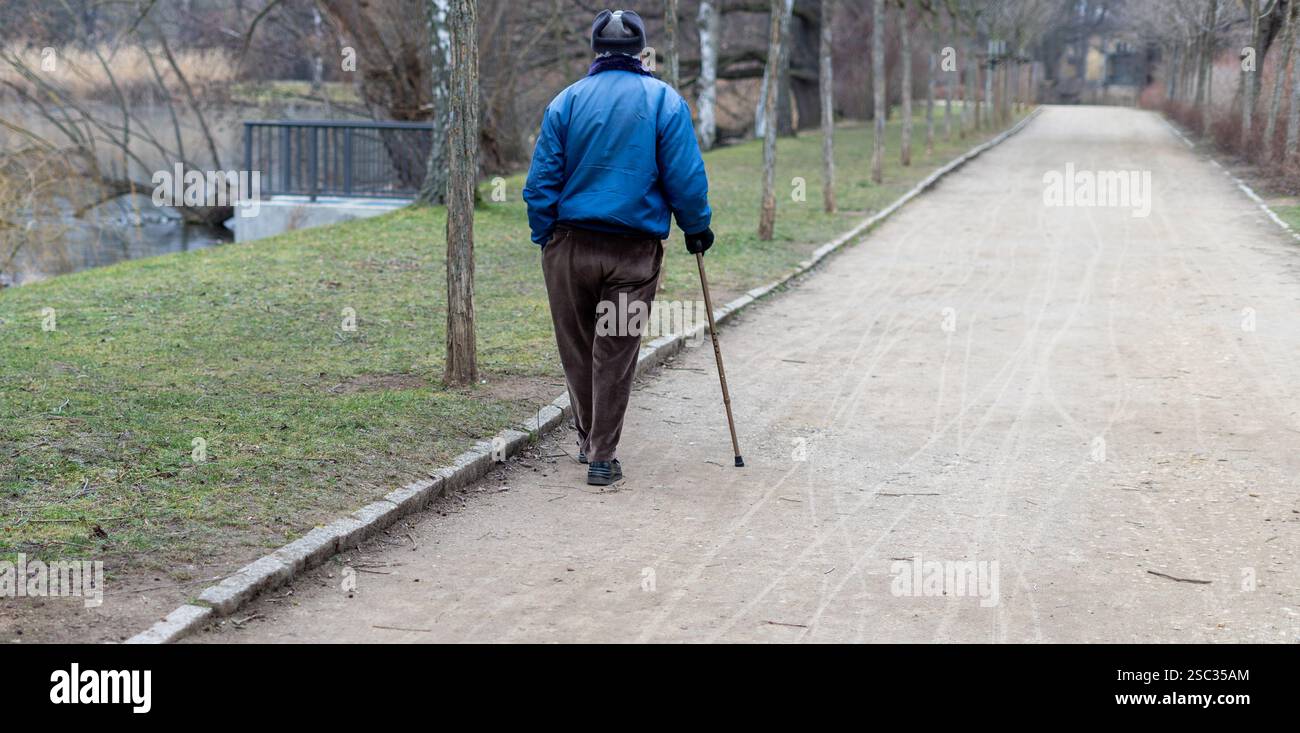 Alter Mann mit Gehstock, der im Park läuft Stockfoto
