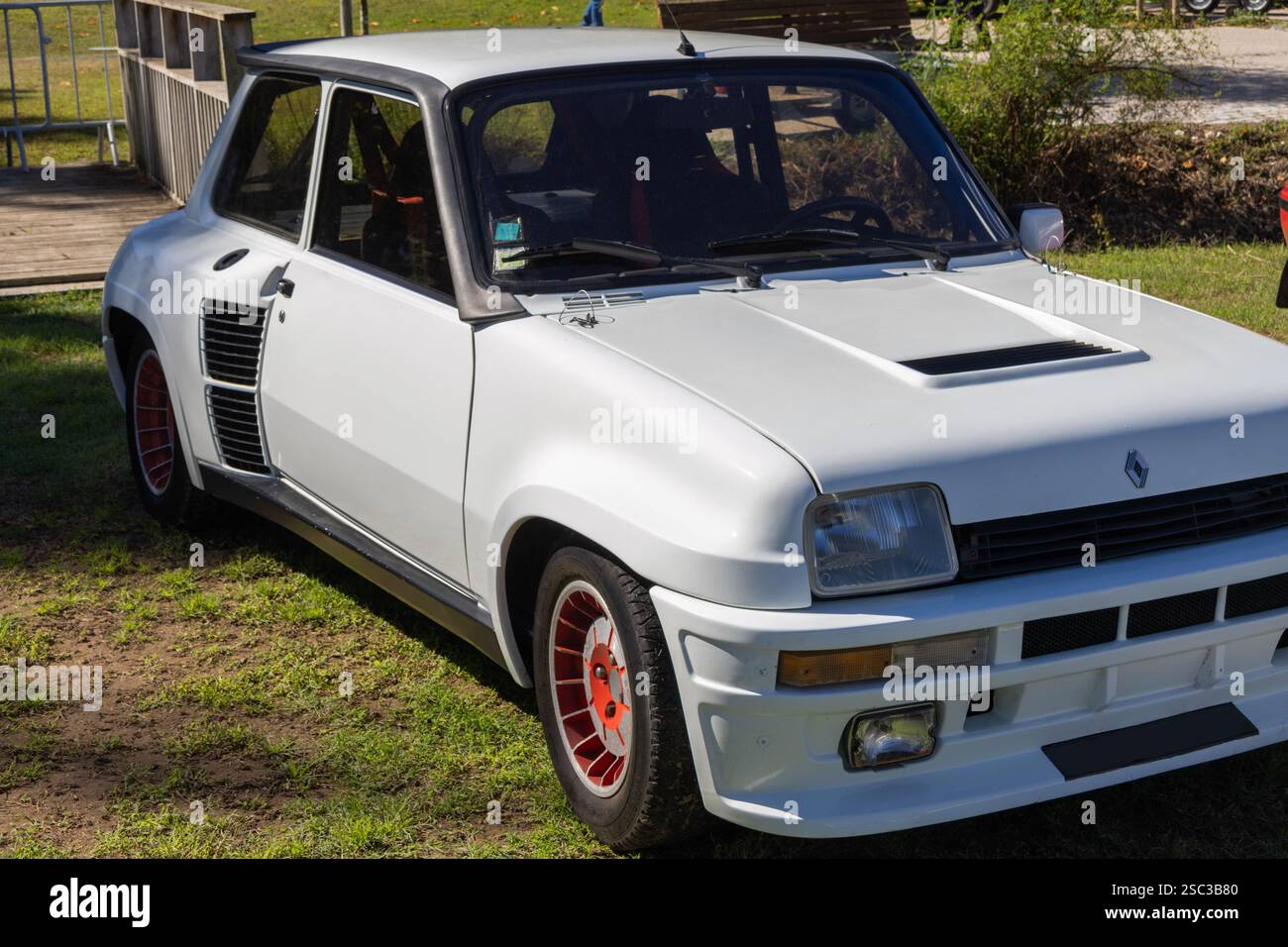 Klassischer weißer renault 5 Turbowagen, der auf Rasen geparkt ist und sein legendäres Design und seine Motorsport-Tradition zeigt Stockfoto