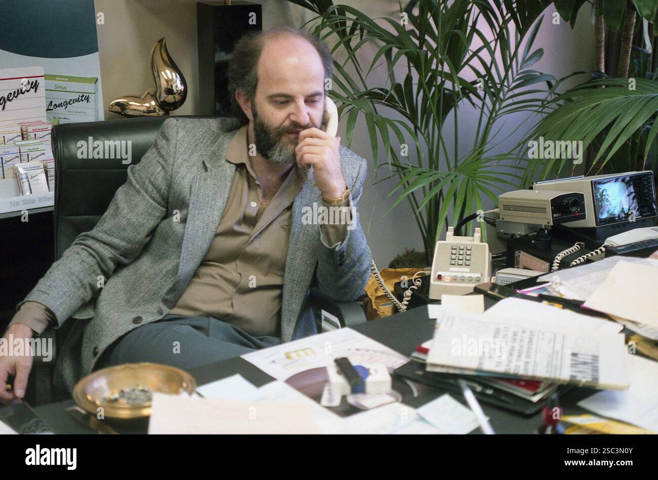 Los Angeles, CA, USA, ca. 1992. Mann in einem modernen, geschäftigen Büro. Stockfoto