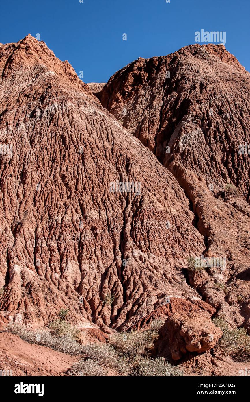 Ein felsiger Berg mit blauem Himmel im Hintergrund. Der Berg ist mit Felsen bedeckt und hat viele Risse Stockfoto