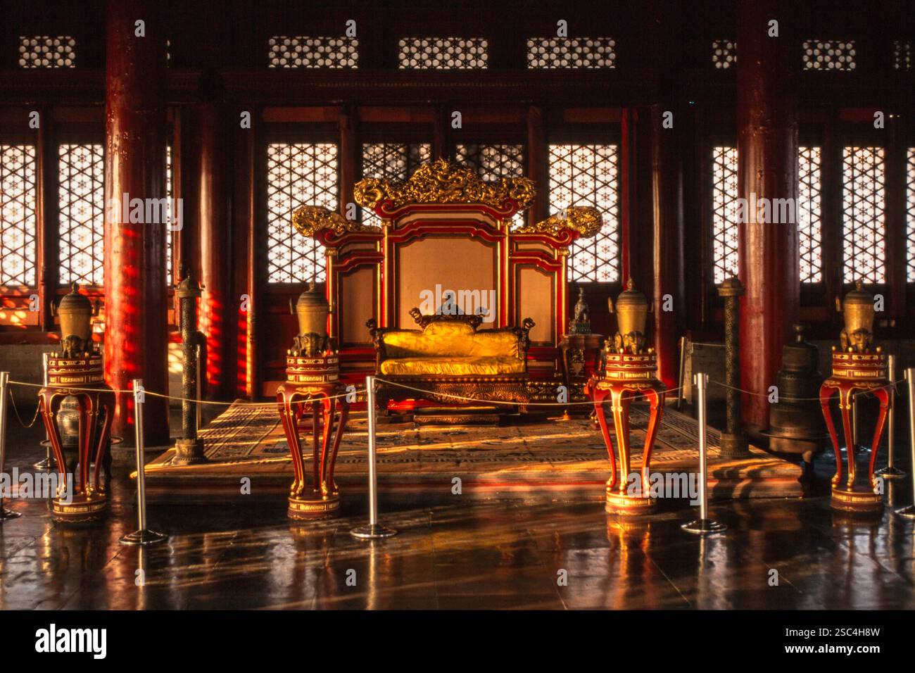 Ein reich dekorierter Thronsaal im Pekinger Kaiserpalast mit roten Säulen und verzierten Details. Stockfoto