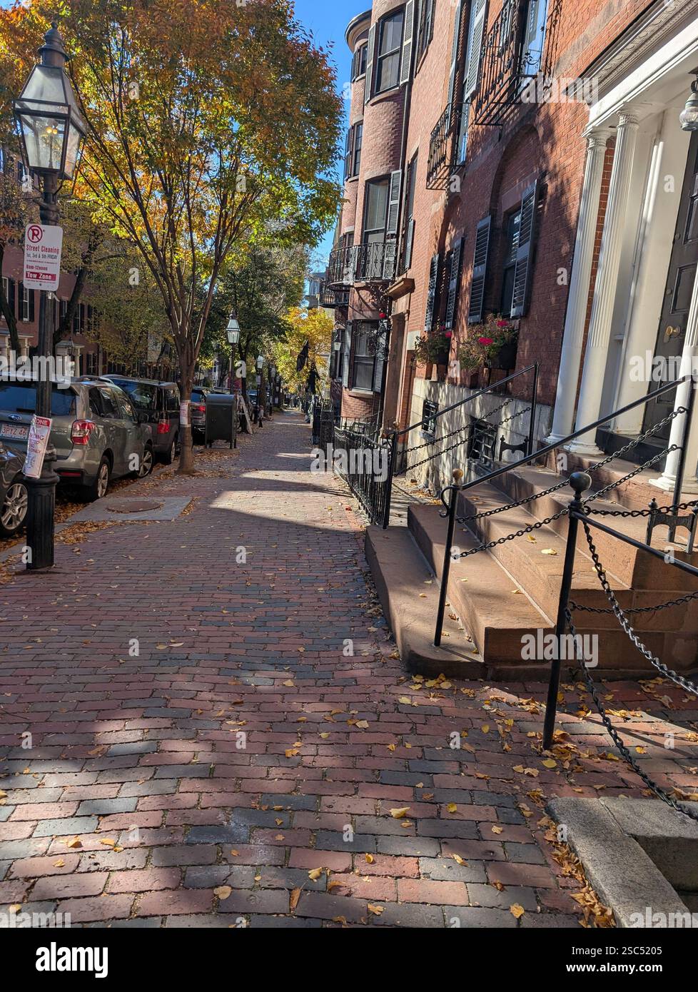 Eine charmante, historische Straße in Boston, Massachusetts, mit Backsteinpflastern und Gebäuden, die an Gebiete älterer Städte erinnern - Smartphone-aufgenommenes Stockfoto