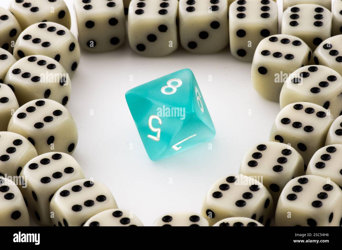 Ein hellblauer, achtseitiger Würfel hebt sich in einem Kreis aus weißen Standardwürfeln hervor und symbolisiert die Einzigartigkeit, Strategie und Zufälligkeit des Tabletop-Gaming. Stockfoto