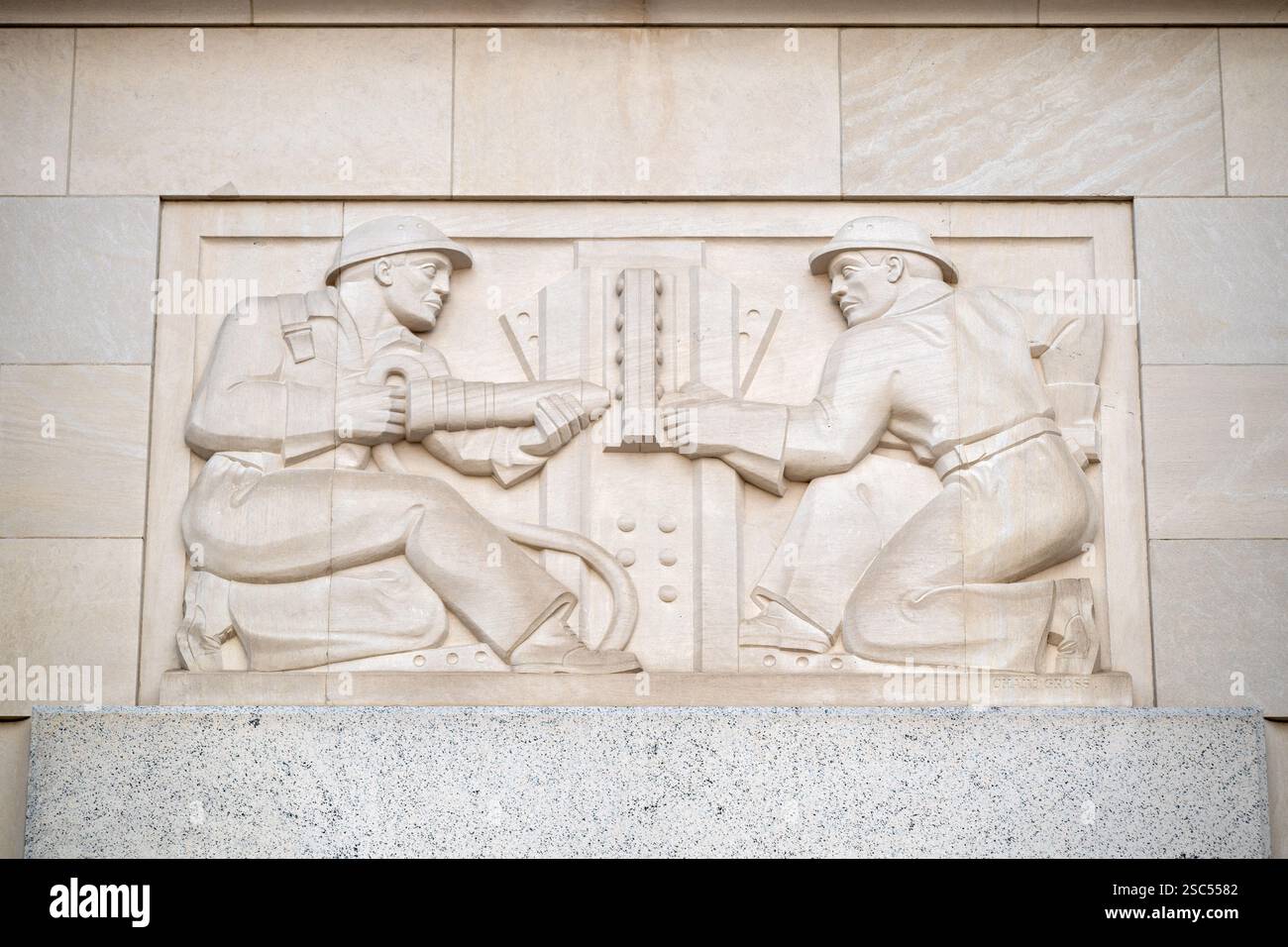 WASHINGTON DC – „Industry“, ein Kalksteinrelief von Chaim Gross, das 1938 fertiggestellt wurde, schmückt den Eingang zum Gebäude der Federal Trade Commission. Die Art déco-Tafel zeigt zwei Stahlbauarbeiter, die Balken zusammennieten, als Teil einer Serie, die verschiedene Formen des Handels veranschaulicht, die die Eingänge des Gebäudes schmücken. Stockfoto