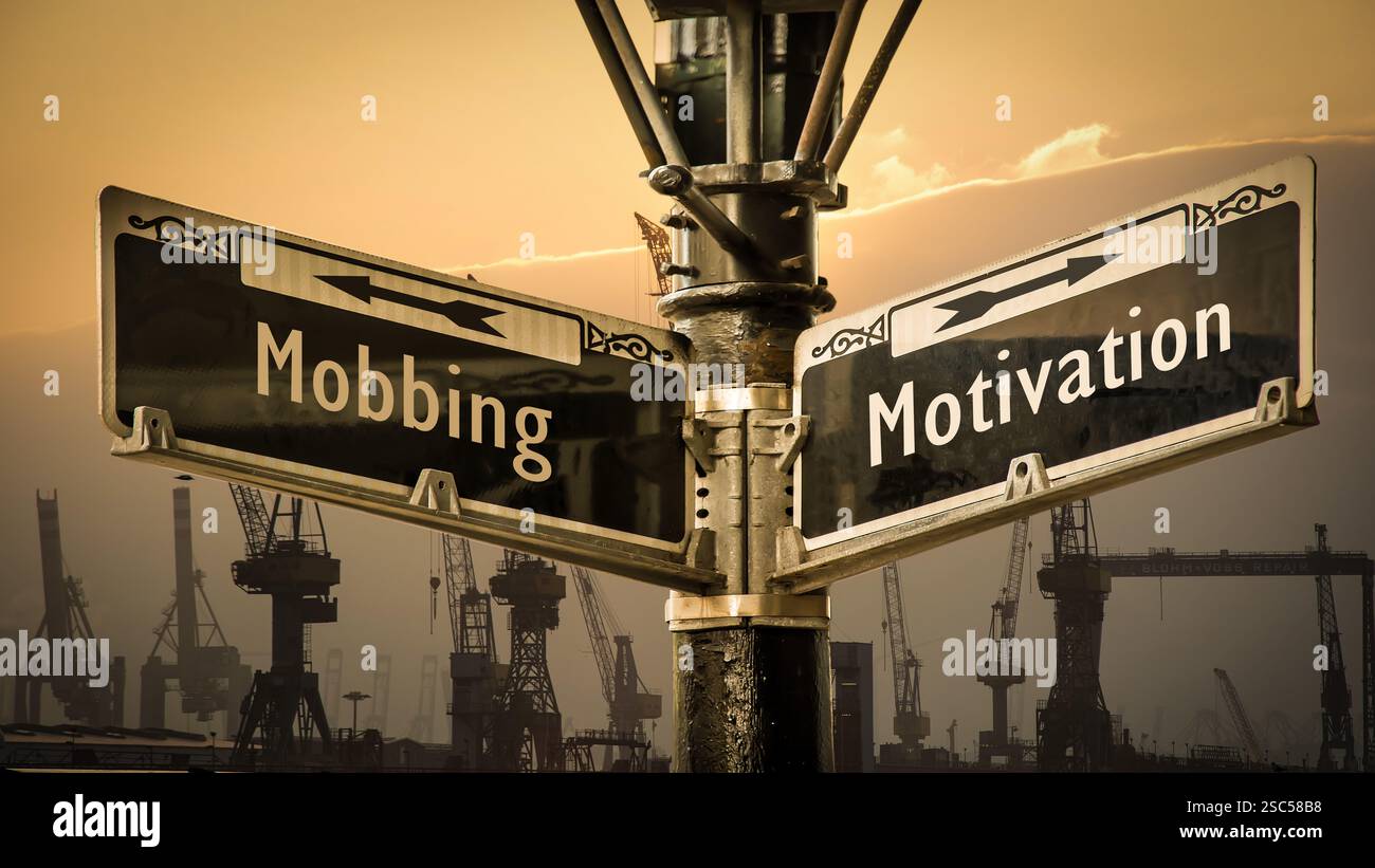Ein Bild mit einem Wegweiser, der in zwei verschiedene Richtungen auf Deutsch zeigt. Eine Richtung verweist auf Motivation, die andere auf Mobbing. Stockfoto