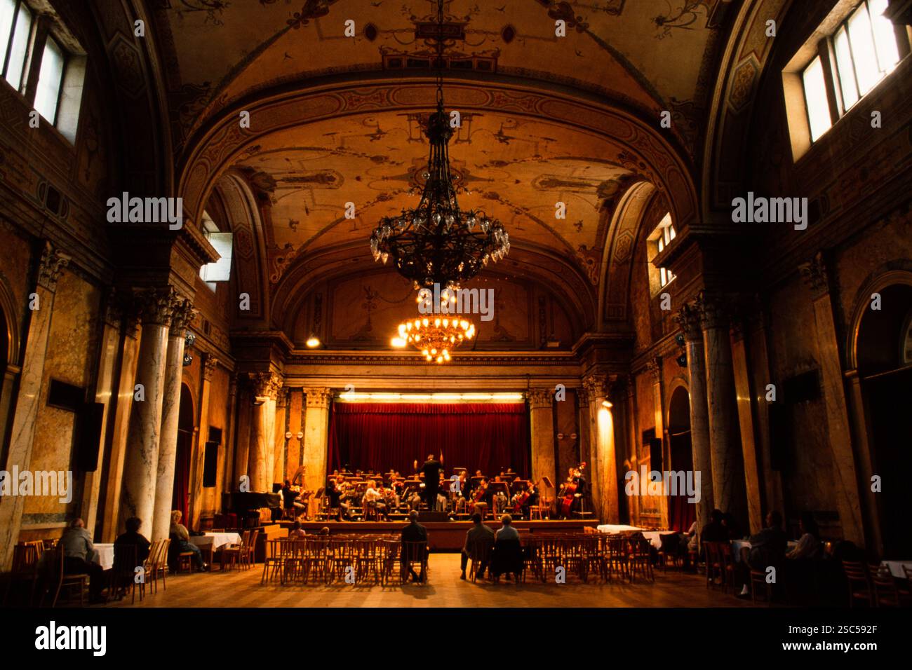 Ein großer Konzertsaal in Wien mit einer Aufführung auf der Bühne, mit eleganter Architektur und einem großen Kronleuchter. Stockfoto