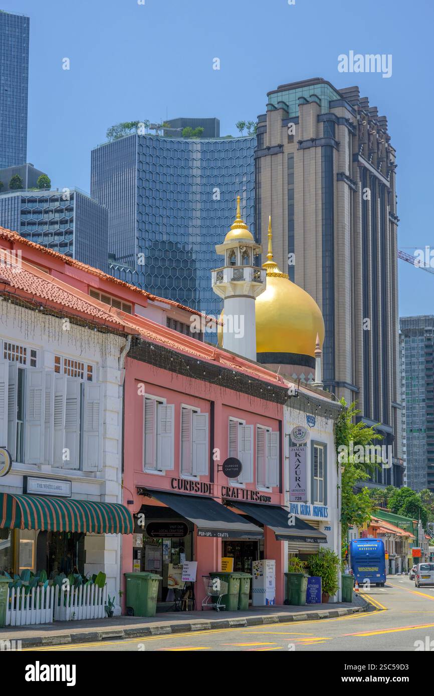 Die goldenen Kuppeln und das schlanke Minarett der Sultan-Moschee von Kampong Glam ragen über die farbenfrohen Geschäfte der North Bridge Road. Stockfoto