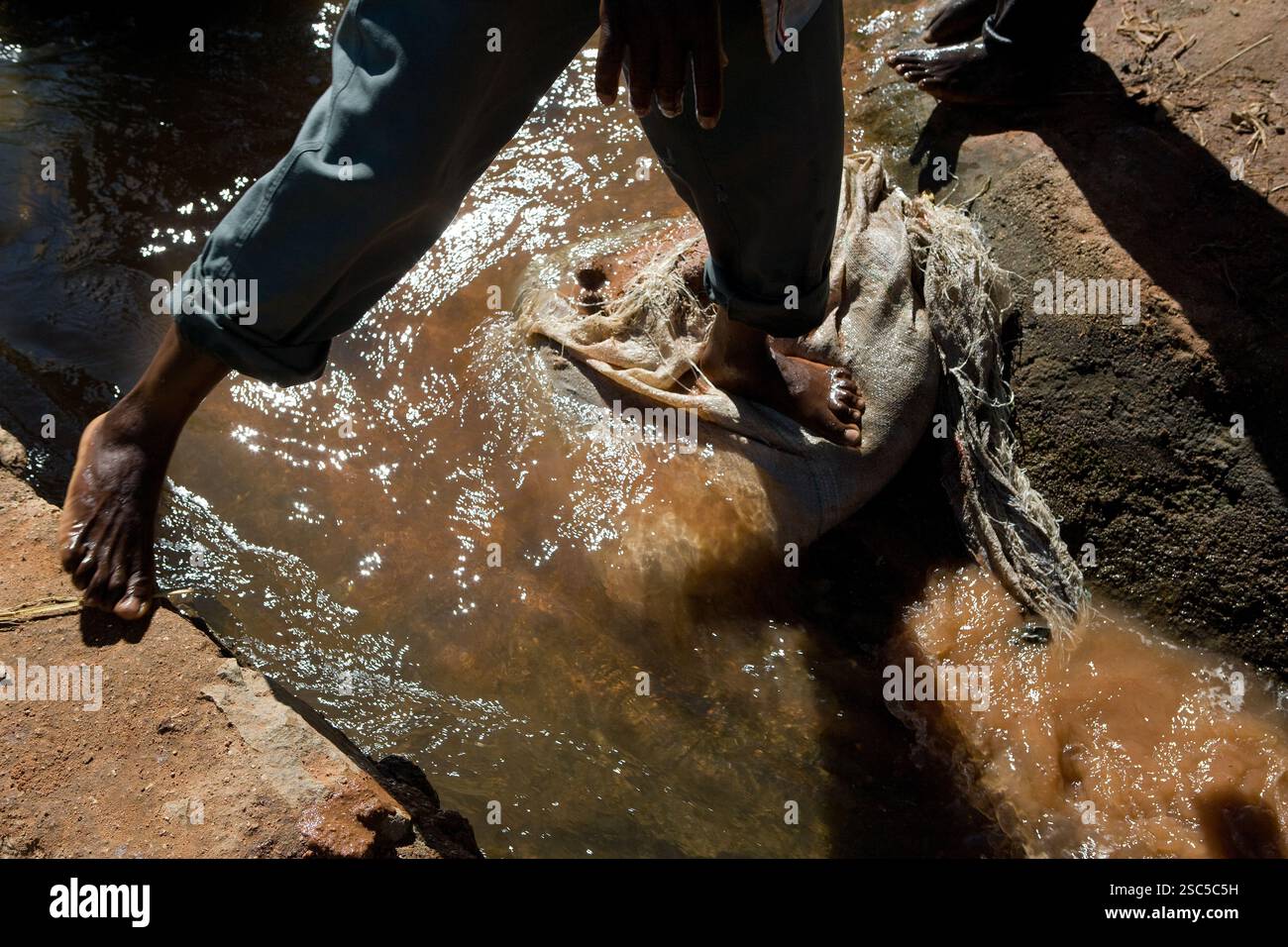 MAKEFU VILLAGE, IDODI DIVISION, IRINGA TANSANIA, Mai 2008: Dorfbewohner, die auf den Bewässerungsgräben herumlaufen, während Wasser an ihnen entlang fließt, um ihre Felder zu bewässern. Foto von Mike Goldwater/Reportage von Getty Images Stockfoto