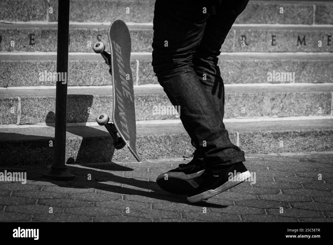 Ein Skateboarder (unbekannt) navigiert durch eine Reihe von Steinstufen. Stockfoto