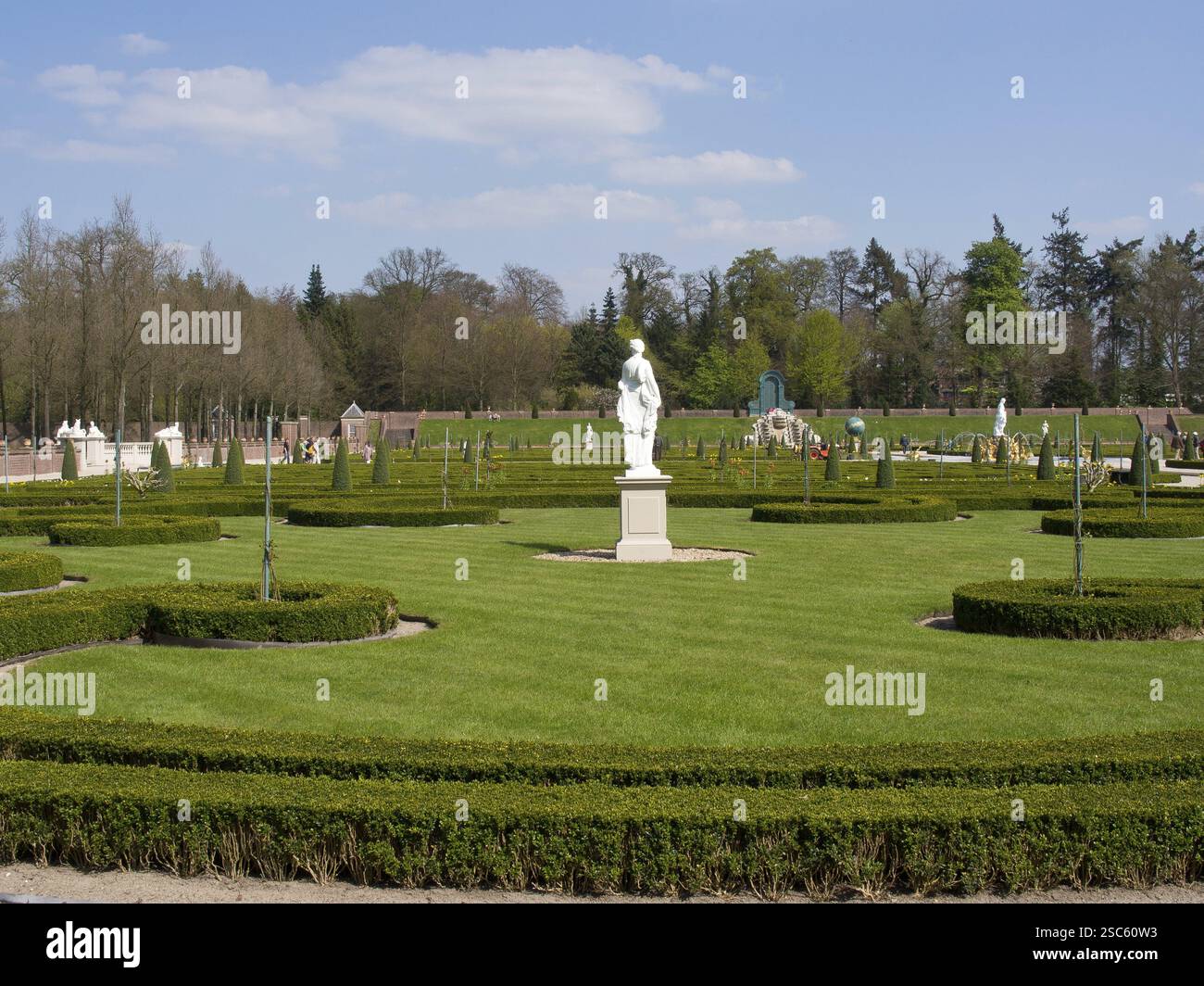 Geräumiger Rasen im Park mit symmetrischem Garten und Statue, Apeldoorn, Niederlande Stockfoto