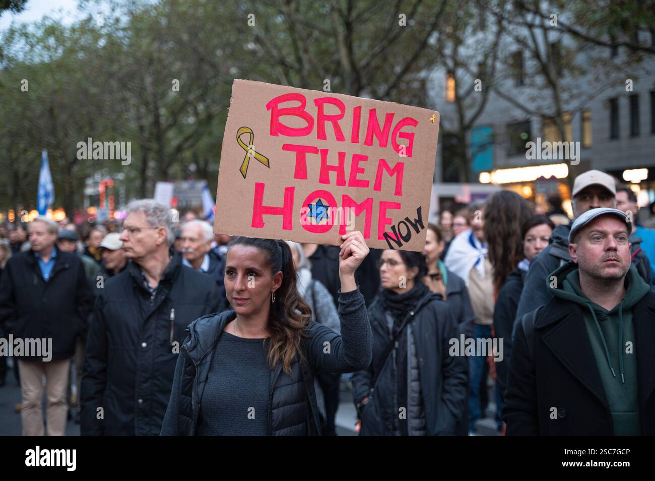 07.10.2024, Deutschland, Berlin, Berlin - Ein Teilnehmer hält ein Protestplakat mit den Worten ìBring Them Home Nowî als symbolisches Zeichen der Solidarität durin Stockfoto