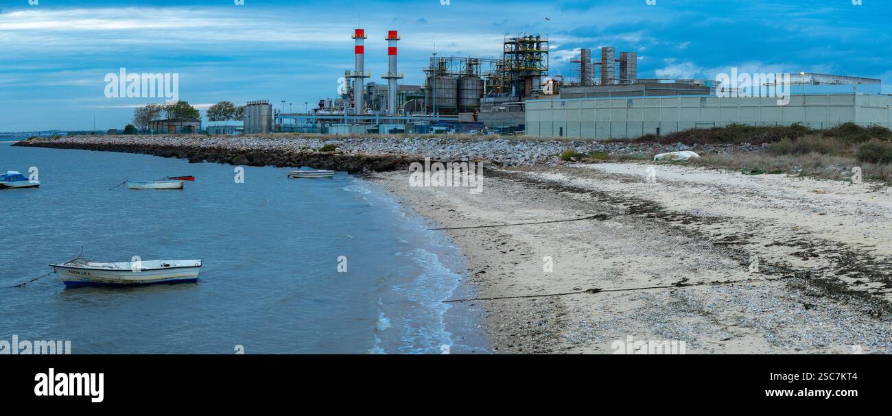 Bild des Flusstrands mit kleinen Booten und Fisipe-Fabrik in lavradio-Portugal. Stockfoto