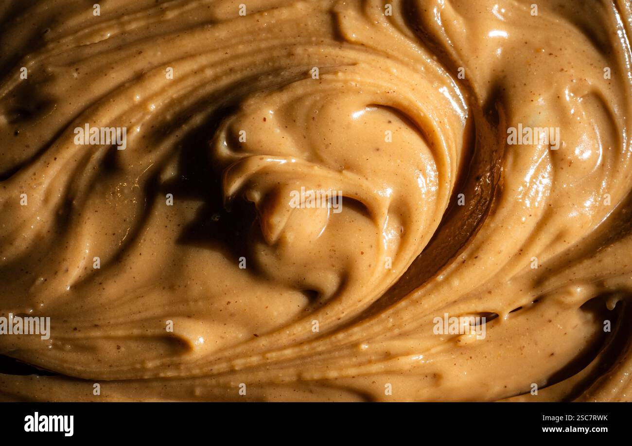 Ein reichhaltiger, samtiger Schuss Erdnussbutter unter warmer Beleuchtung. Stockfoto