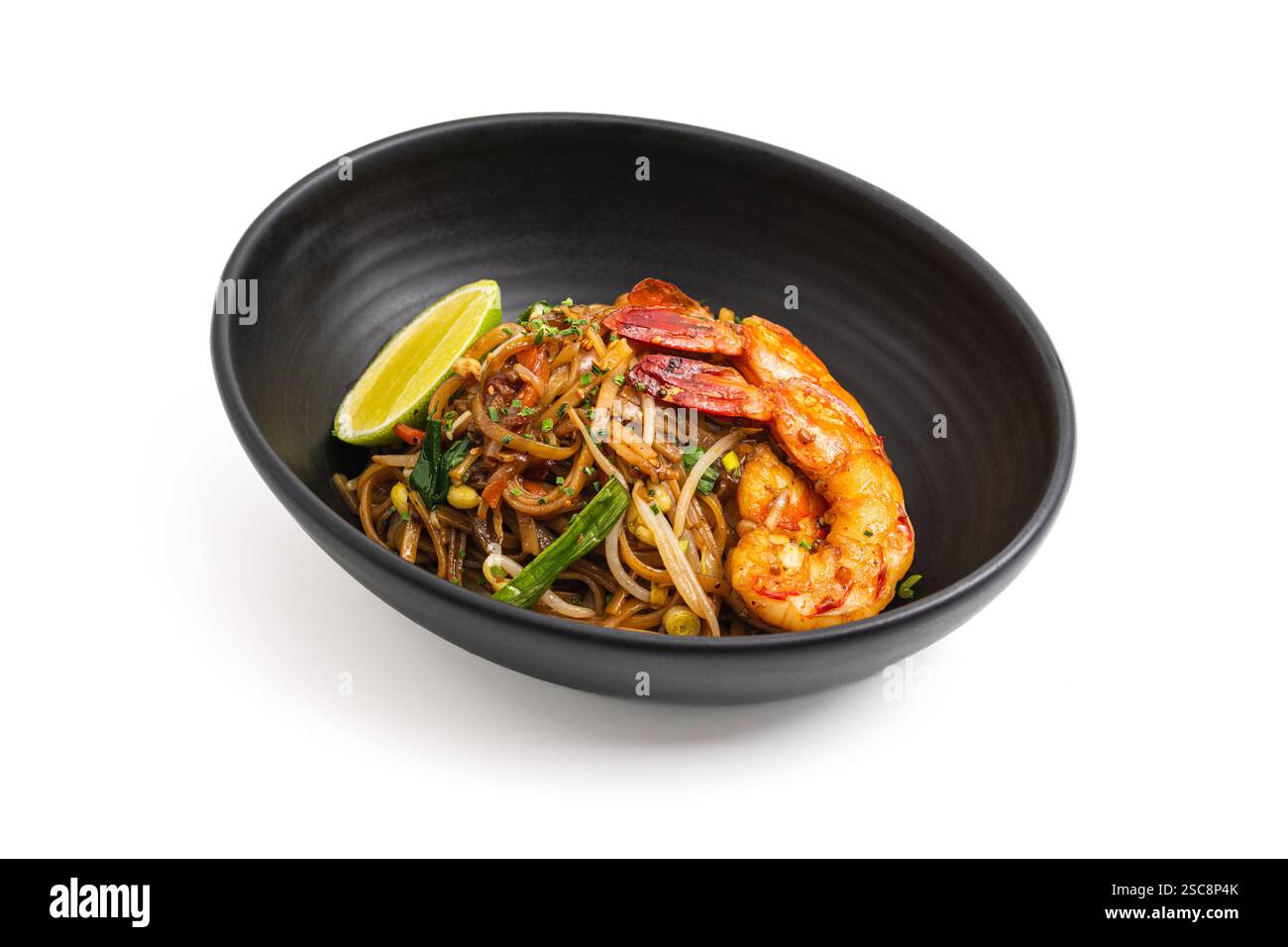 Blick von oben auf Shrimps Pad Thai mit Limette in einer schwarzen Schüssel Stockfoto