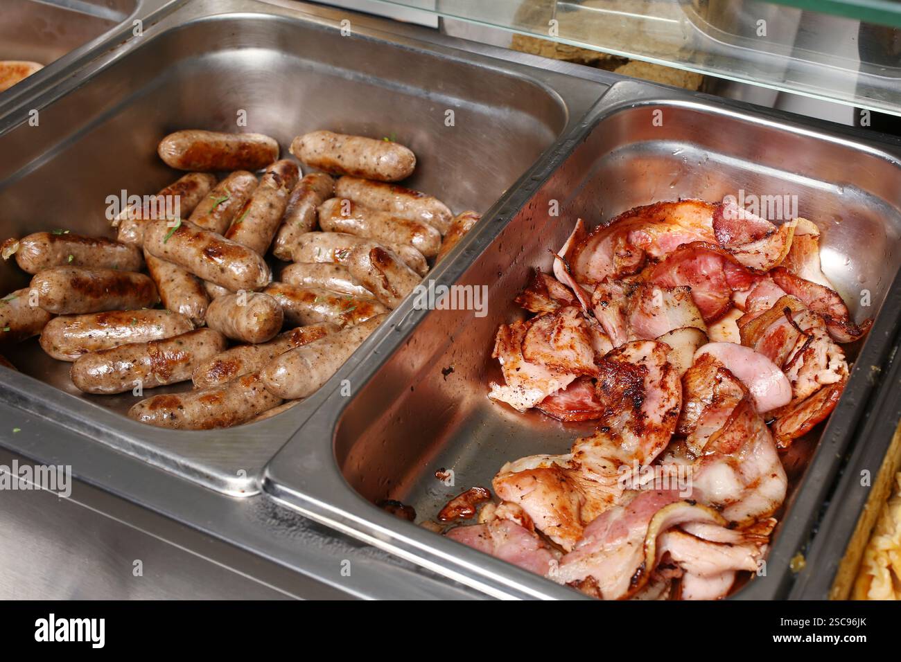 Gebratene Würstchen und Speck Stockfoto