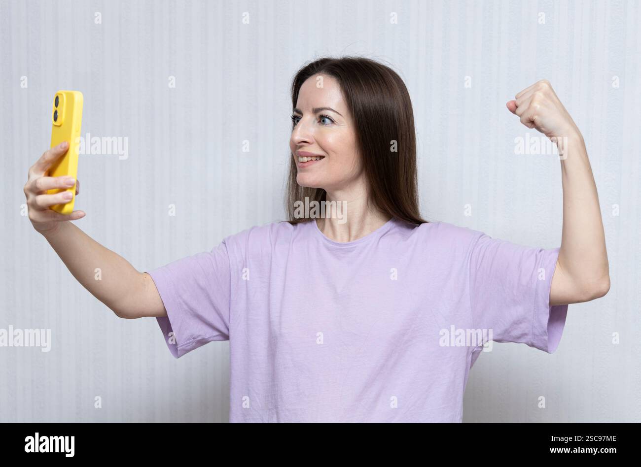 Beschleunigen Sie die Aktion IWD2025. AccelerateAction. Internationaler Frauentag. Tag am 8. märz. Die Frau zeigte während eines Videoanrufs Kraft, Stärke Stockfoto