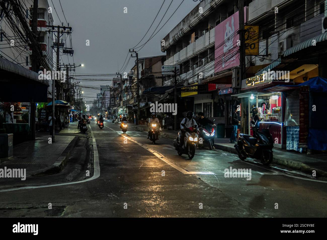 Bangkok, Thailand. Februar 2025. Pendler auf Motorrädern werden durch den Smog navigiert, bevor die Staus in den Straßen von Bangkok, Thailand, beginnen. Bei Sonnenaufgang laufen und joggen die Menschen durch die trüben Straßen, trotz schlechter Luftqualität aufgrund der hohen Luftverschmutzung, die die kühlere Luft optimal nutzt, bevor die Hitze des Tages einsetzt. Pendler auf Motorrädern und Autos navigieren durch den dichten Smog, bevor der Stau beginnt. Quelle: SOPA Images Limited/Alamy Live News Stockfoto