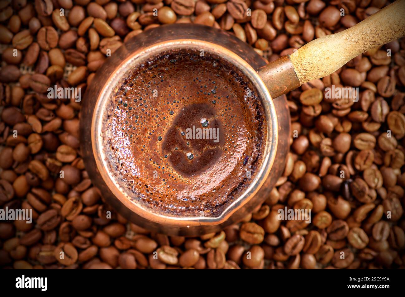Traditioneller türkischer Kaffee in Kupferkaffeekanne mit Kaffeebohnen auf Sacksack, Heißgetränk-Konzept Stockfoto