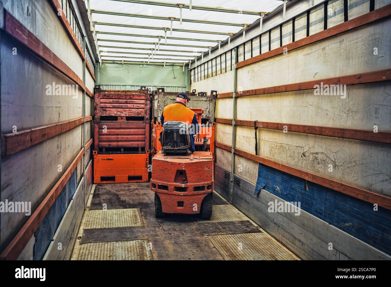 Gabelstaplerfahrer im Overall bei der Arbeit im Lager Stockfoto