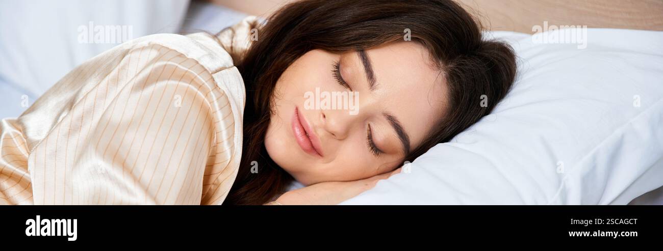 Eine schöne junge Frau genießt einen ruhigen Schlaf, während sie einen weichen, satinierten Pyjama in ihrem gemütlichen Bett trägt. Stockfoto