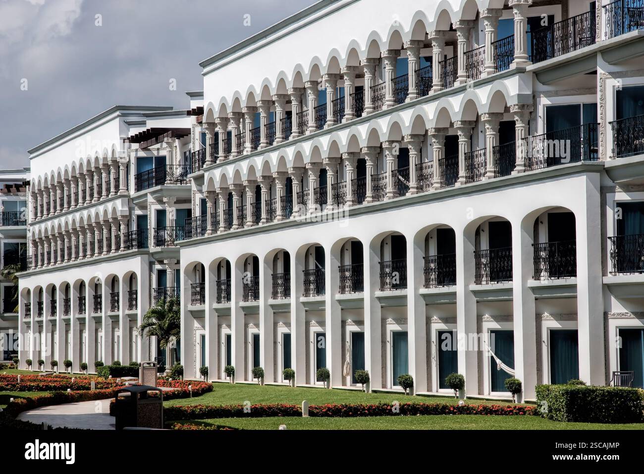 Ein großes Gebäude mit Bogenfenstern und Balkonen. Das Gebäude ist weiß. Es gibt viele Balkone im Gebäude Stockfoto