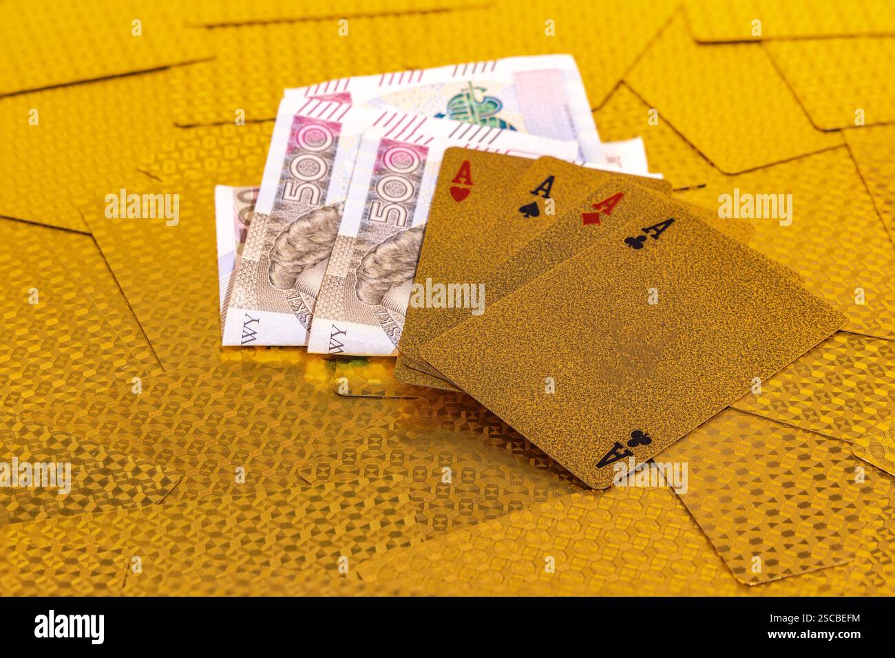 500 Zloty-Banknoten als Gewinn in einem Pokerspiel, goldene Poker-Karten in den Händen eines Casino-Spielers Stockfoto