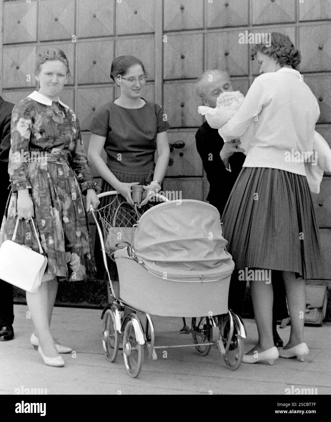 Nach der Taufe in der Heilig-Kreuz-Kirche in Kreuzberg steht die Familie vor der Kirche um den Kinderwagen und hält das Kind in den Armen. [Automatisierte Übersetzung] Stockfoto