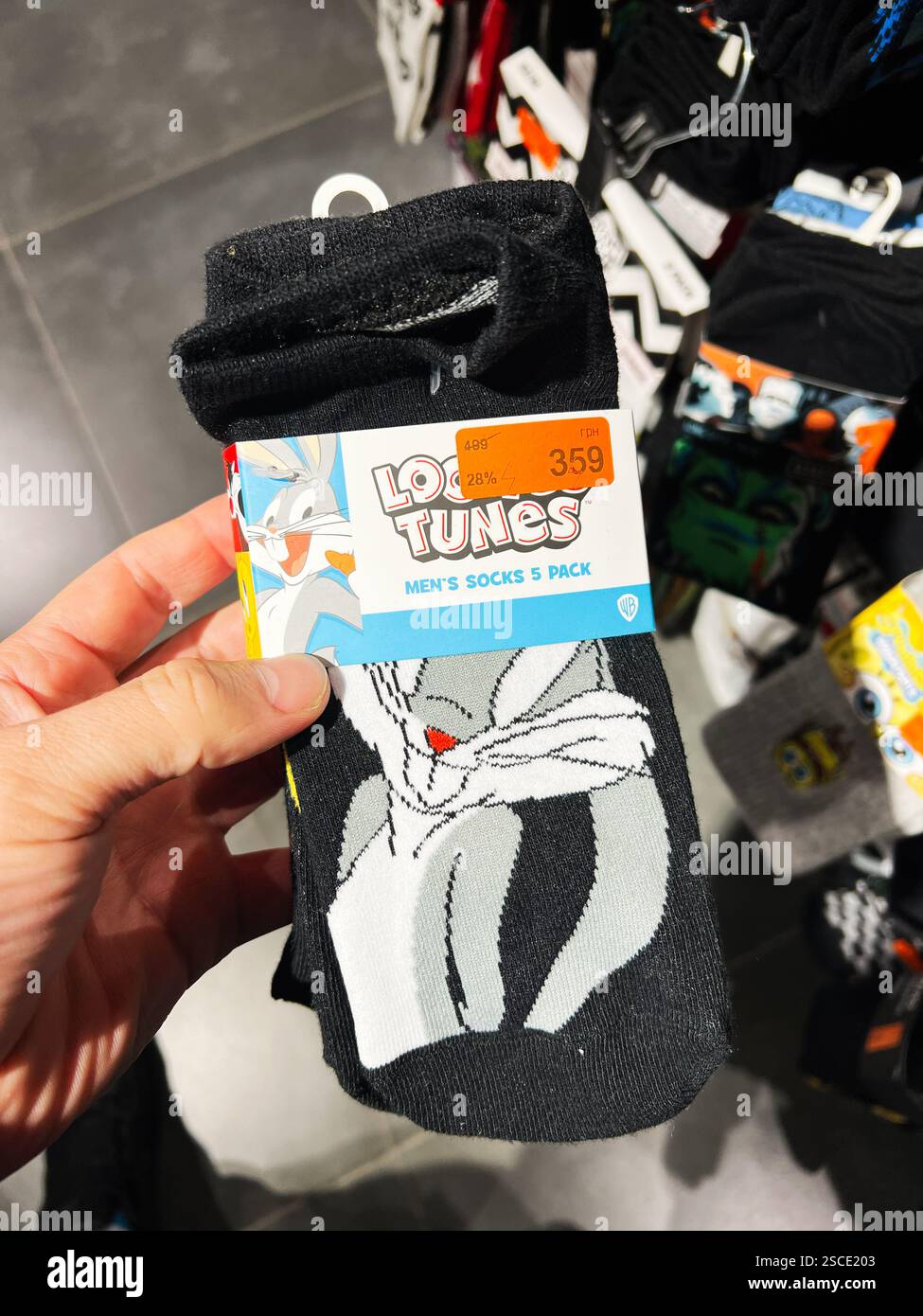Kiew, Ukraine - 05. Februar 2025: Bunte Looney Tunes Socken auf einem Kleiderständer in einem Bekleidungsgeschäft ausgestellt. Stockfoto