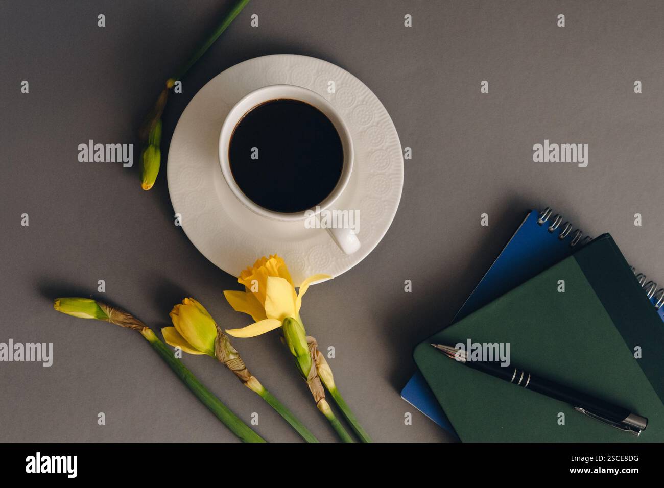 Büro- und Frühlingskonzept mit einer Tasse Kaffee und Frühlingsblumen. Stockfoto