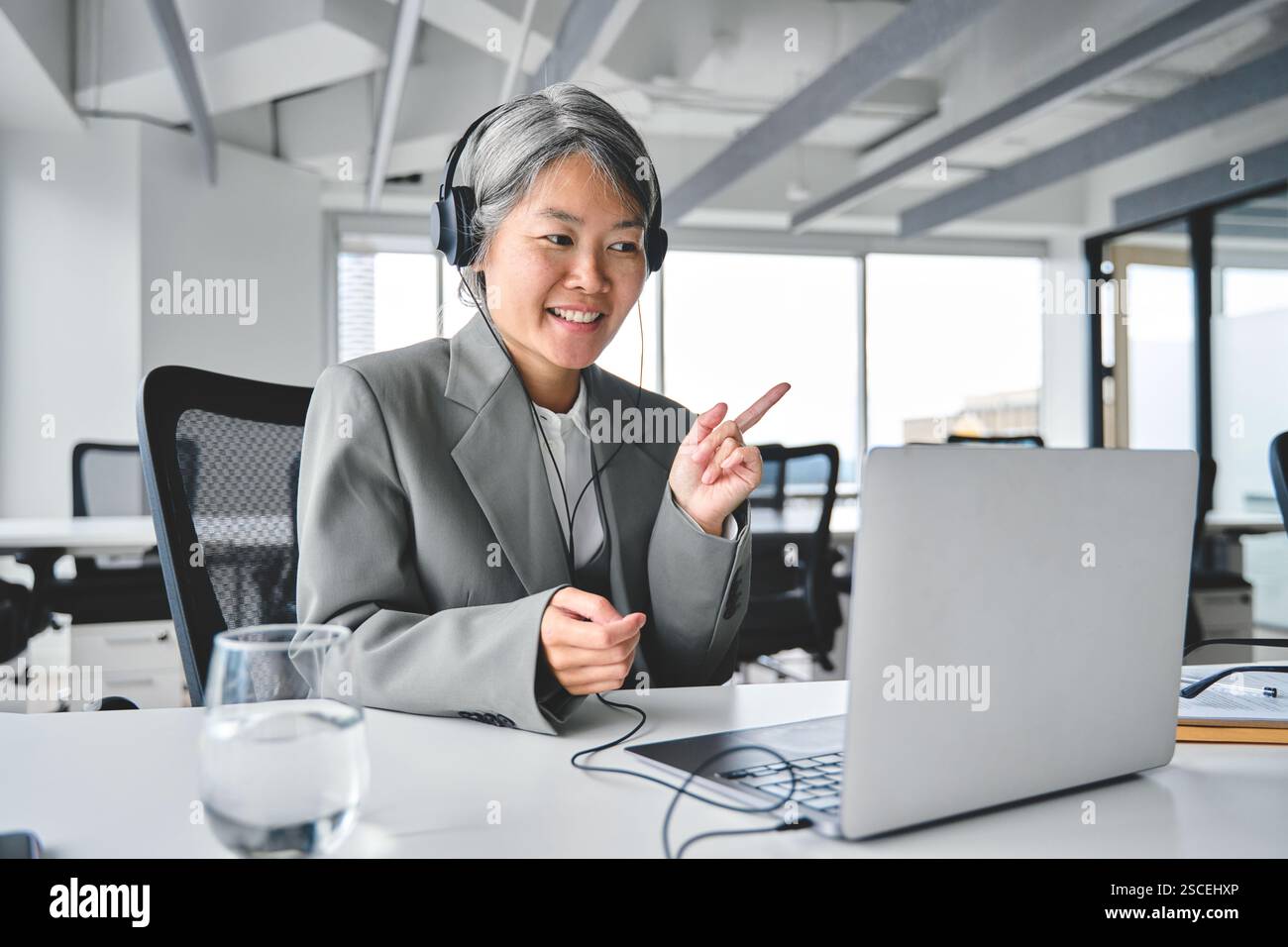 Glückliche ältere asiatische Geschäftsfrau, die ein virtuelles Meeting mit Laptop hat. Stockfoto