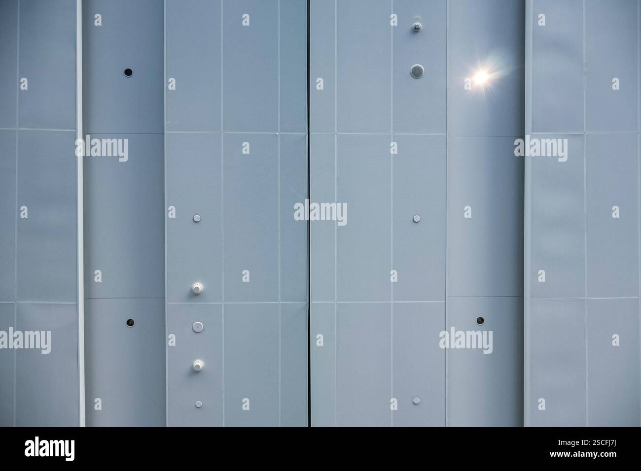 Der Hintergrund ist eine perforierte Metallstruktur, industrieller Minimalismus. Stockfoto
