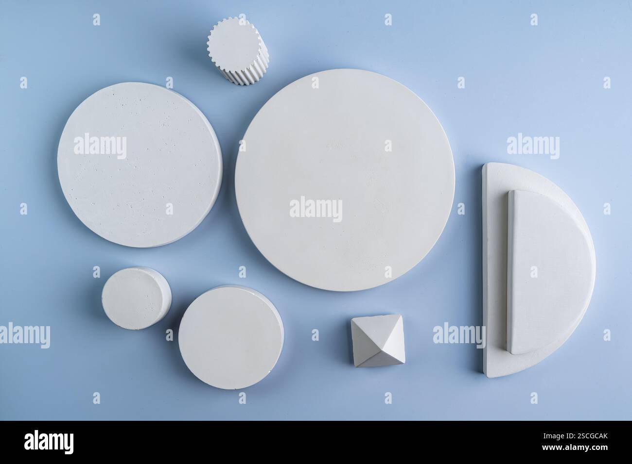 Weiße geometrische Podeste aus Betonkreisen verschiedener Formen und Pyramiden. Podeste für Showinf-Produkte. Stockfoto