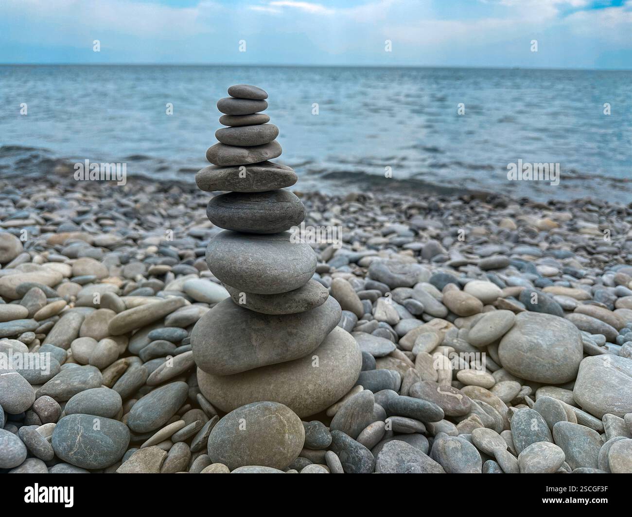 Steine, die in Pyramiden gestapelt sind und am Meer stehen, symbolisieren die Ruhe und das buddhistische Konzept Stockfoto
