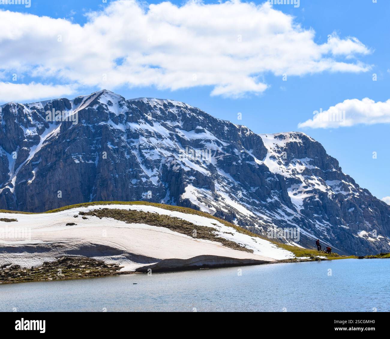 Alpensee in den Bergen mit schmelzendem Schnee Stockfoto