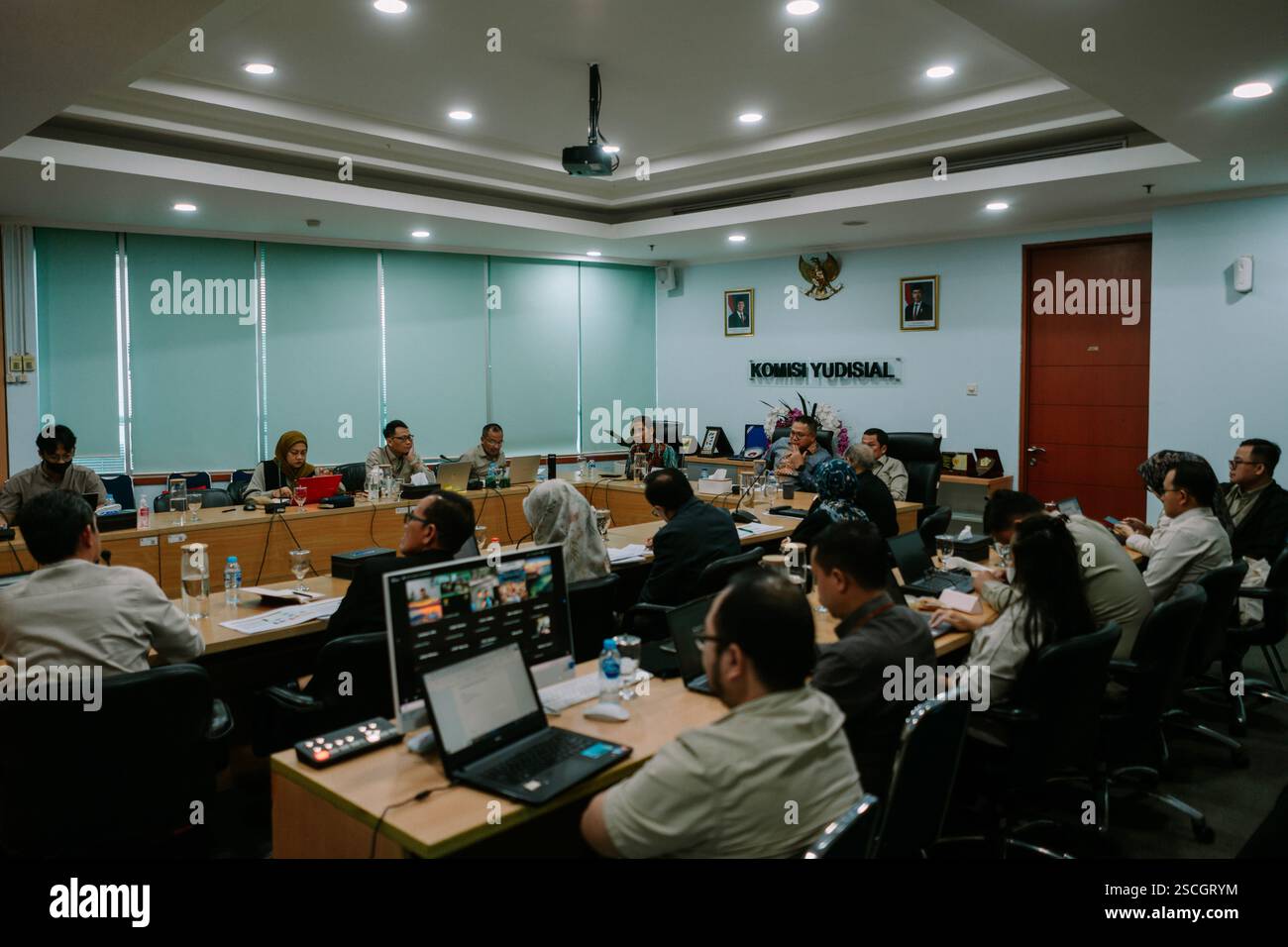 Jakarta, 6. Februar 2025. Gruppe von Personen, die an einer Besprechung in einem formellen Konferenzraum teilnehmen und sich auf eine Präsentation konzentrieren. Stockfoto