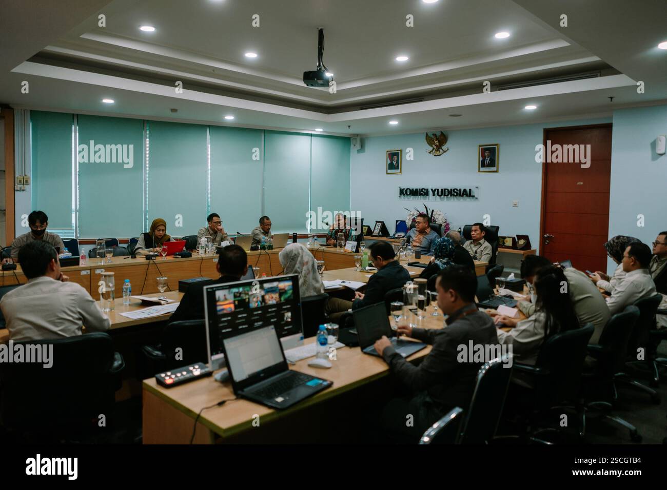 Jakarta, 6. Februar 2025. Gruppe von Personen, die an einer Besprechung in einem formellen Konferenzraum teilnehmen und sich auf eine Präsentation konzentrieren. Stockfoto